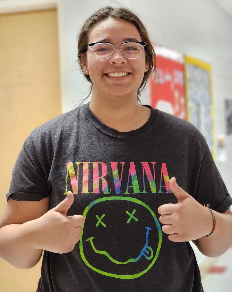 A student gives a thumbs up for 90's Spirit Day. 